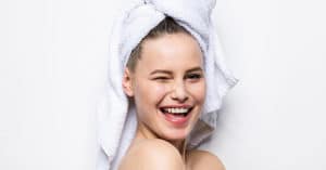 mujer sonriendo con toalla en la cabeza