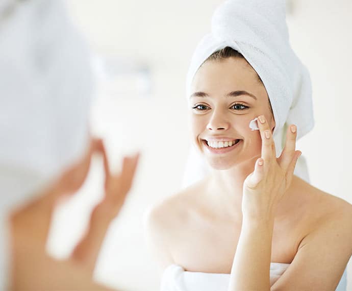 mujer aplicando crema en su cachete