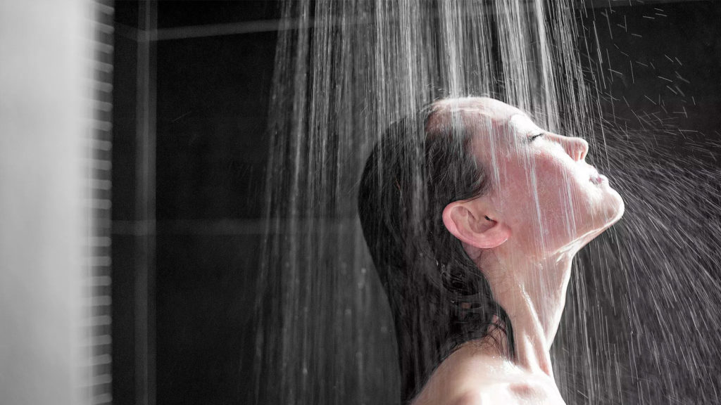 mujer disfrutando un baño en la regadera